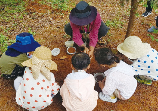 아이들이 숲에서 흙체험을 하고 있다